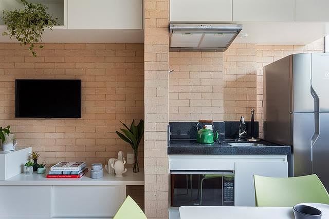 Khu vực bếp được ngăn cách với kệ trang trí phòng khách bằng một bức tường gạch dày.