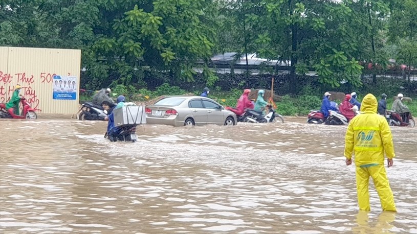 Nước ngập sâu quá nửa bánh xe tại đường gom đại lộ Thăng Long.