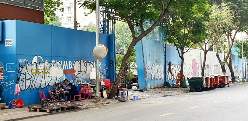 B&ecirc;n ngo&agrave;i dự &aacute;n Trụ sở Eximbank tại số 7 L&ecirc; Thị Hồng Gấm, Quận 1, TP Hồ Ch&iacute; Minh đang được "tận dụng" l&agrave;m nơi tập kết thu gom r&aacute;c thải v&agrave; qu&aacute;n nước (Ảnh: Thi&ecirc;n An/Thương trường)