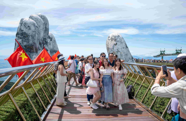 Cầu V&agrave;ng rực rỡ sắc cờ hoa, tiếp tục l&agrave; điểm đến kh&ocirc;ng thể thiếu, thu h&uacute;t d&ograve;ng người đổ về trong dịp lễ.